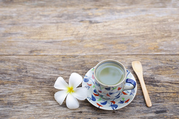 Tea in classic cup with flower on wooden table