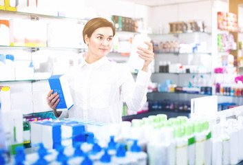 Fototapeta premium Young female customer is browsing rows of body care products