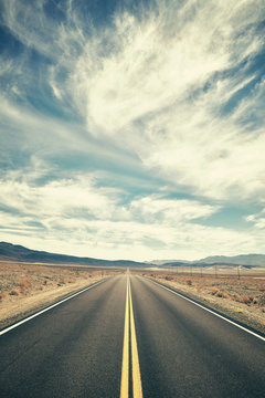 Vintage toned desert road in Death Valley, travel concept, USA.