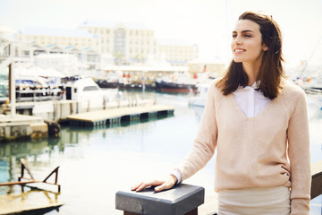 Fototapeta premium Beautiful woman at city waterfront, looking away