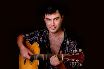Obraz premium Young man playing acoustic guitar - isolated on black