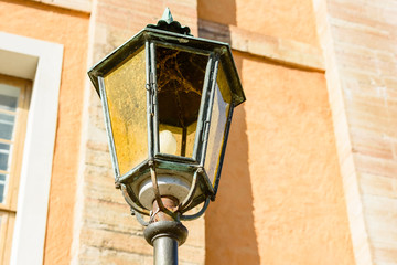 Old and broken lamppost outside a building.