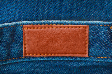 close up of blank leather label on blue denim for graphic design or branding