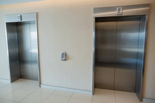 Two elevator doors in lobby of office building