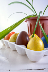 Chocolate egg among colored easter eggs.