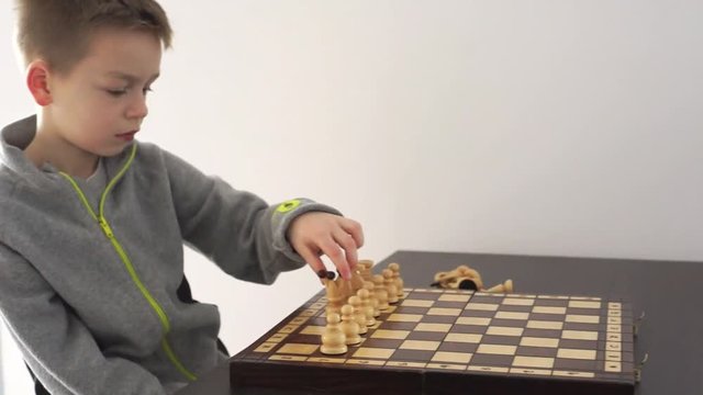 chłopiec układa szachy
