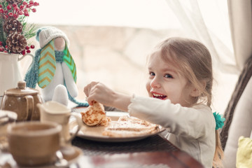 Obraz na płótnie Canvas Little pretty girl eating breakfast,