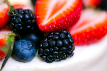 A slide of berries: strawberries, blueberries and blackberries are decorated with a cake