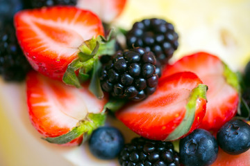 A slide of berries: strawberries, blueberries and blackberries are decorated with a cake