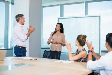 Fototapeta premium colleagues clapping for businesswoman in conference room