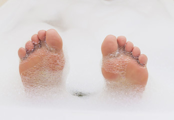 Young woman feet covered in foam.