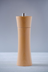 wooden grinder for salt or pepper on gray background