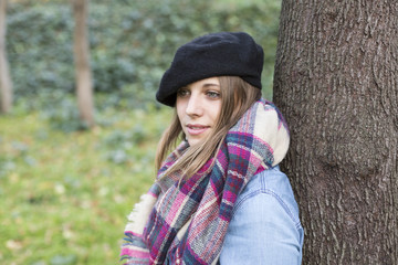 outdoors portrait of a beautiful young woman looking at the camera and smiling. Woman posing in autumn. sunset