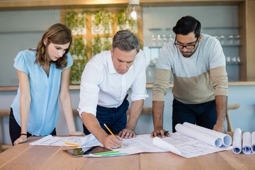 Architects working over blueprint in conference room