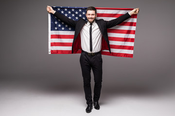 Business man in suit holding USA flag from his back with open mouth