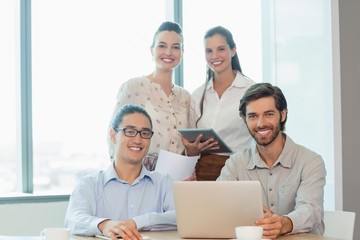 Smiling business executives using laptop
