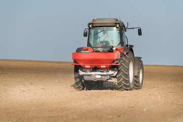 Tractor spreading artificial fertilizers