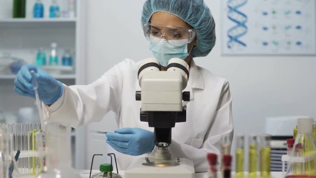 Medical worker doing blood analysis on microscope at laboratory, health-care