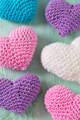 knitted hearts on turuoise wooden surface