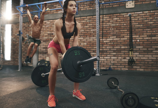 Woman preparing to lift barbell in gym