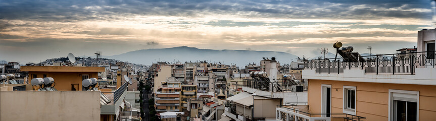 Fototapeta premium Panoramic view of sunset over the roofs in the city of Piraeus port in Greece