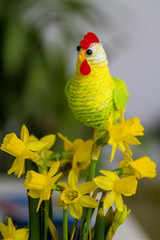 Colourful Easter decoration hen with yellow narcissus vertical