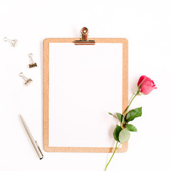 Clipboard mock up and pink rose flower pattern on white background. Flat lay, top view. Flower background.