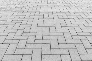 Paver brick floor also call brick paving, paving stone or block paving. Manufactured from concrete or stone for road, path, driveway and patio. Empty floor in perspective view for texture background.