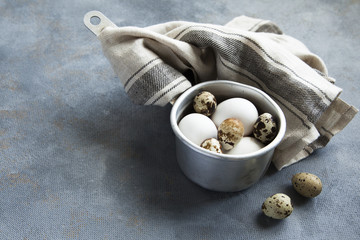 Sauce pan with raw hen and quail eggs.