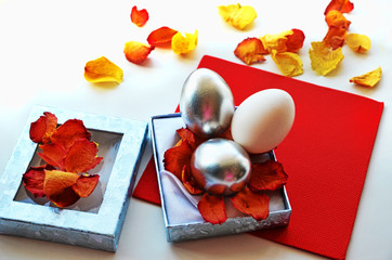 Easter composition. Colored silver eggs in a decorative box, rose petals. Staining of Easter eggs.