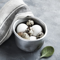 Sauce pan with raw hen and quail eggs.