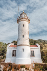 Fototapeta na wymiar Lighthouse at Gelidonya cape, coastline of Mediterranean sea, Turkey. Location nearby Kanaoz, Kemer and Antalya turkish resort city. Famous travel destination. Vertical orientation.