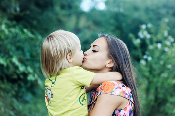 Cute little child kissing and hugging pretty mother