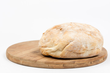 Round domestic bread isolated with wooden board