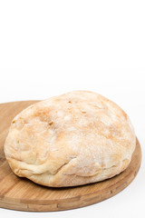 Round domestic bread isolated with wooden board
