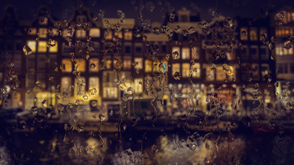 Amsterdam houses view through the glass with raindrops