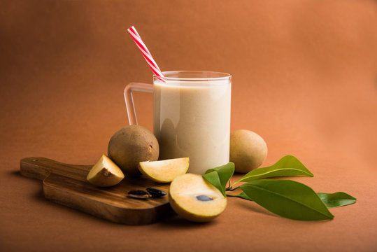 tasty and healthy Chikoo or chiku Milkshake Recipe (Sapota Milkshake) | Chikku Milkshake with chopped pieces over wooden chopping board and green leaves