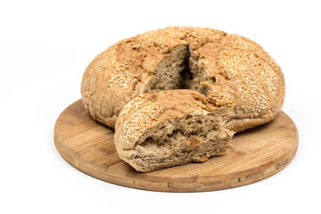 Round domestic bread sliced on the wooden board