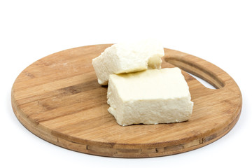 White feta cheese slices on the wooden board