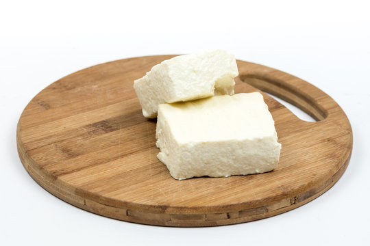White feta cheese slices on the wooden board