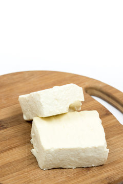 White feta cheese slices on the wooden board