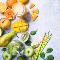 Green and yellow smoothie in mason jar. Top view concrete table