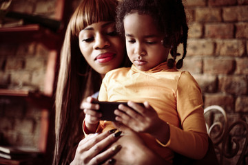 Little African girl using smart phone.