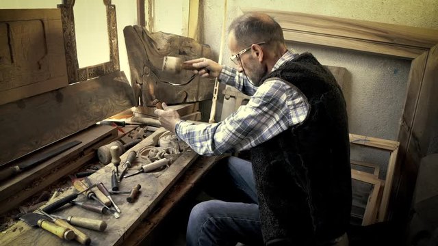 Wood carving. Carver with chisel and hammer. A skillful craftsman working on a panel of wood carve decoration