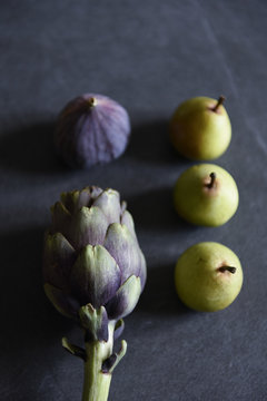 Seasonal vegetables and fruits, artichokes, pears, figs, violet potatoes and Brussels sprouts to be cooked