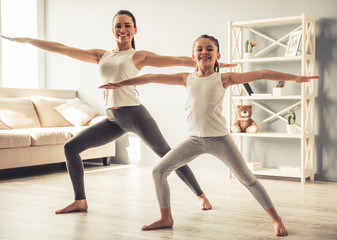 Obraz premium Mom and daughter doing yoga