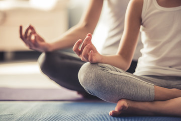 Mom and daughter doing yoga - obrazy, fototapety, plakaty