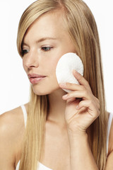 Beautiful woman cleansing face, close up