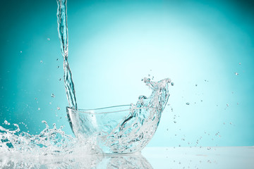 The water splashing to glass bowl on white background