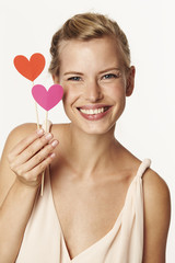 Beautiful woman holding love hearts, smiling